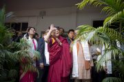 Его Святейшество Далай-лама машет рукой вышедшим, чтобы приветствовать его, студентам Индийского института управления. 11 марта 2013 г. Мирут, штат Уттар-Прадеш, Индий. Фото: Тензин Чойджор (офис ЕСДЛ).