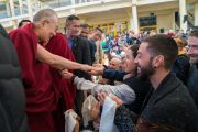 Покидая главный тибетский храм по завершении встречи с более чем 600 иностранными паломниками, Его Святейшество Далай-лама останавливается, чтобы пожать руки участникам встречи. Дхарамсала, Индия. 5 марта 2018 г. Фото: Тензин Чойджор.